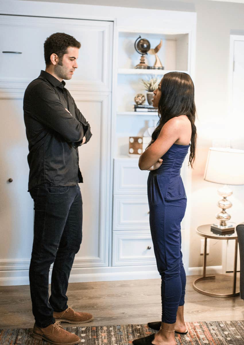 couples with their arms crossed facing each other in a stand off