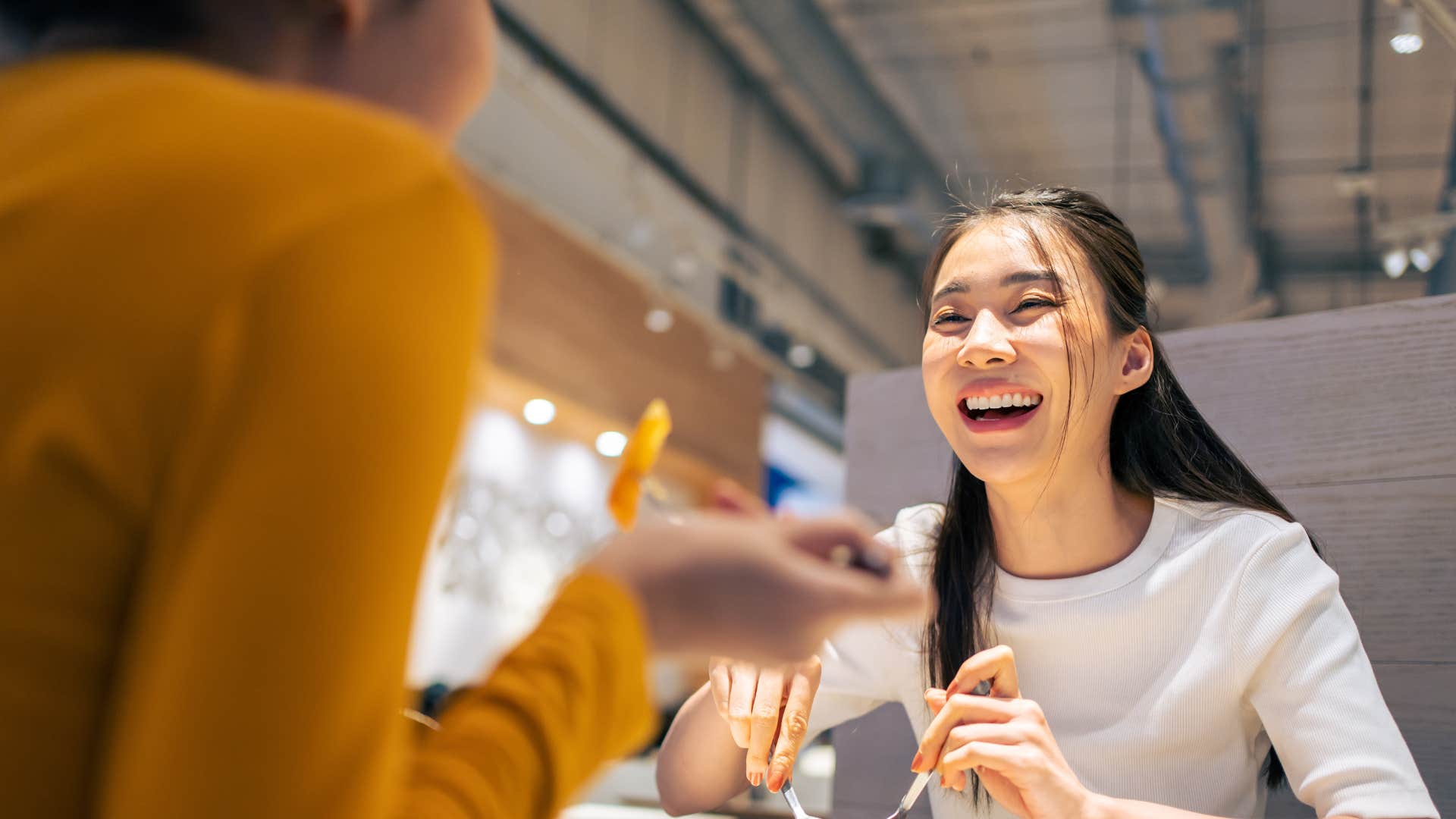 woman pretending to be wealthy mocking frugality with friend