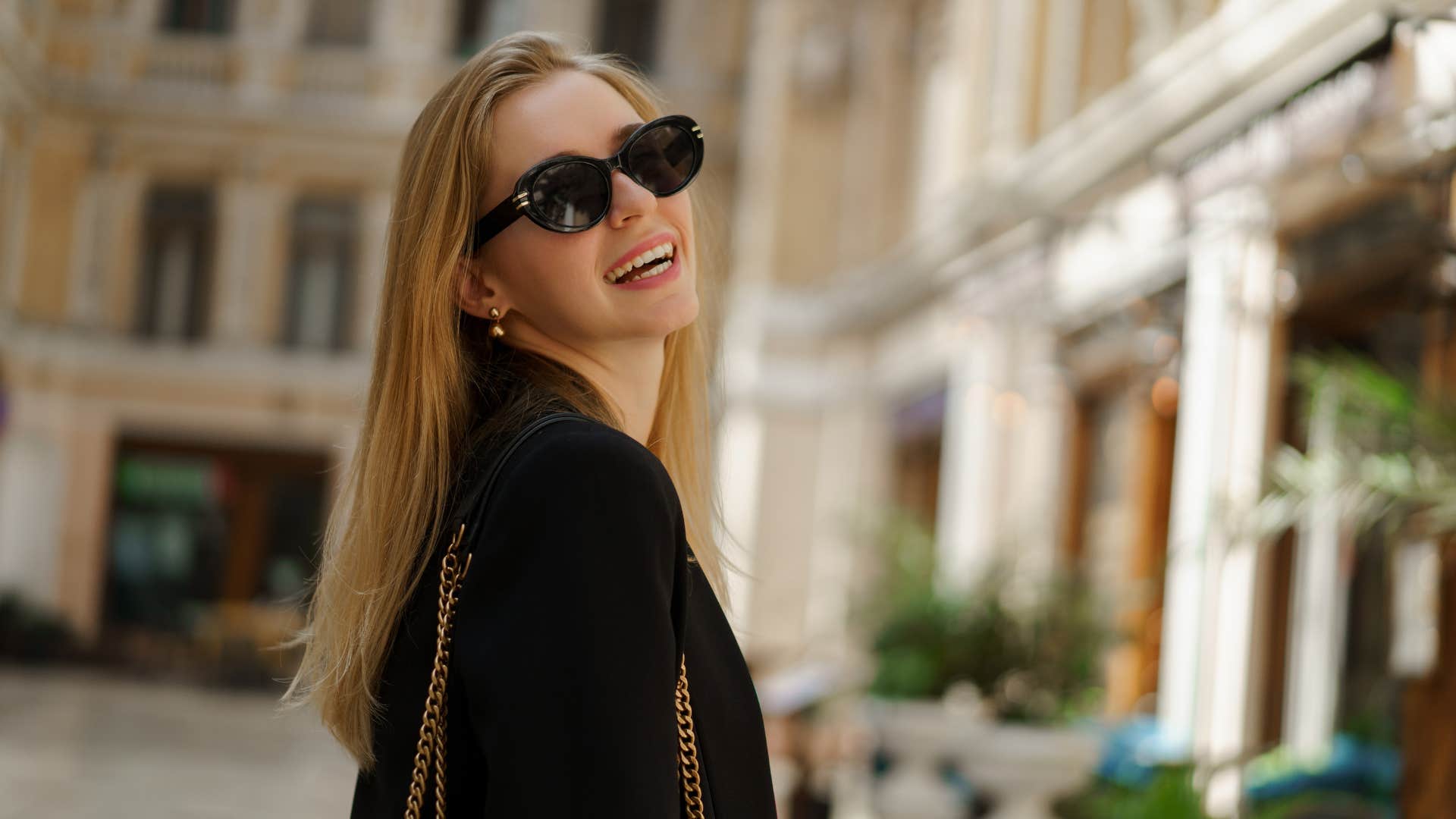 woman pretending to be wealthy wearing expensive clothes outside