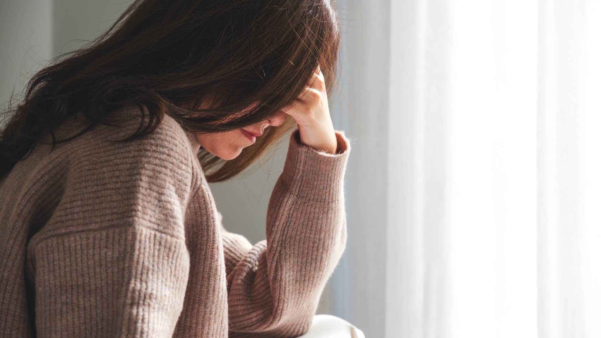 woman who has a migraine with the symtom of a throbbing in her head