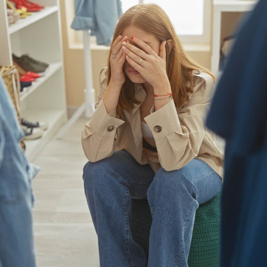 Woman sitting in her closet with a refund pile.