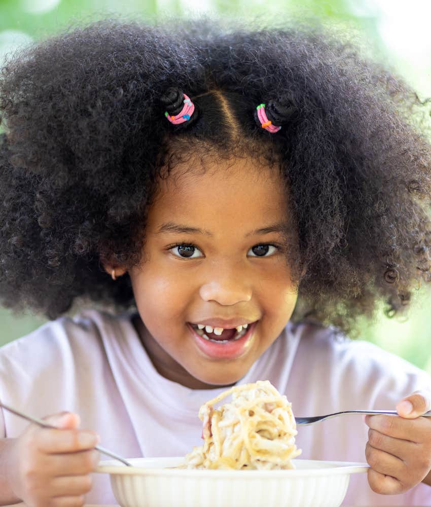 Well behaved child smiles while eating