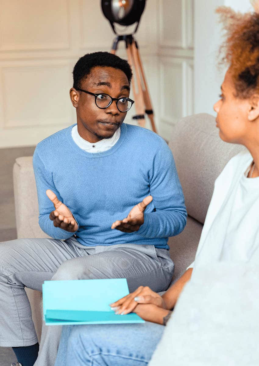 man shrugging his shoulders at a woman