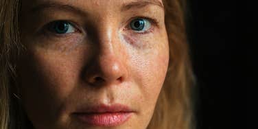 freckled woman feeling sad thinking about her rough childhood