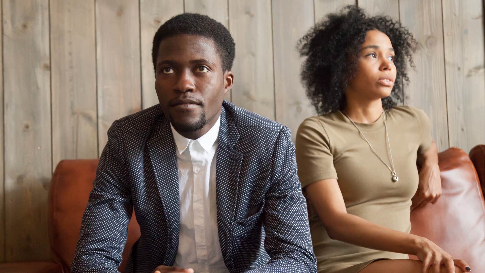 Emotional couple look away from each other showing they grew up differently 