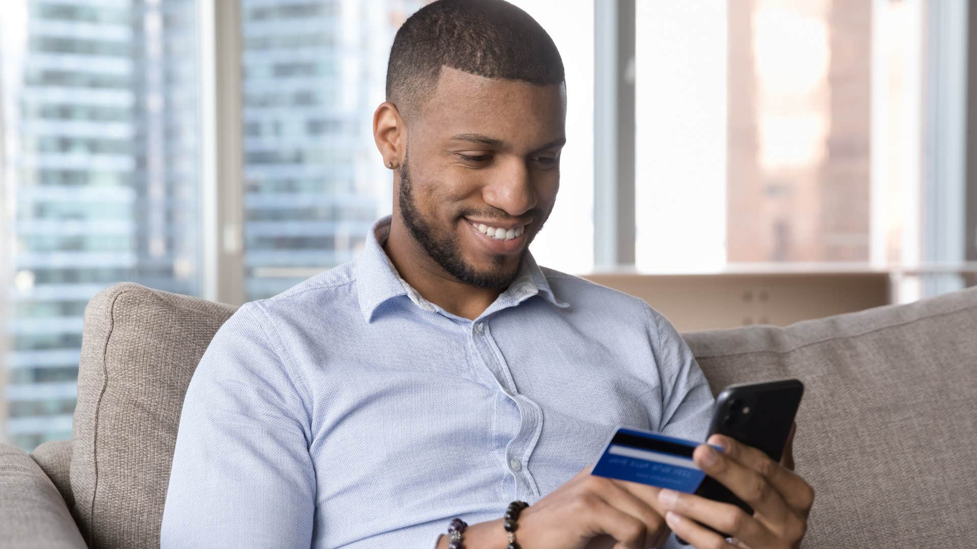 man who's a wasteful spender making a purchase on his phone