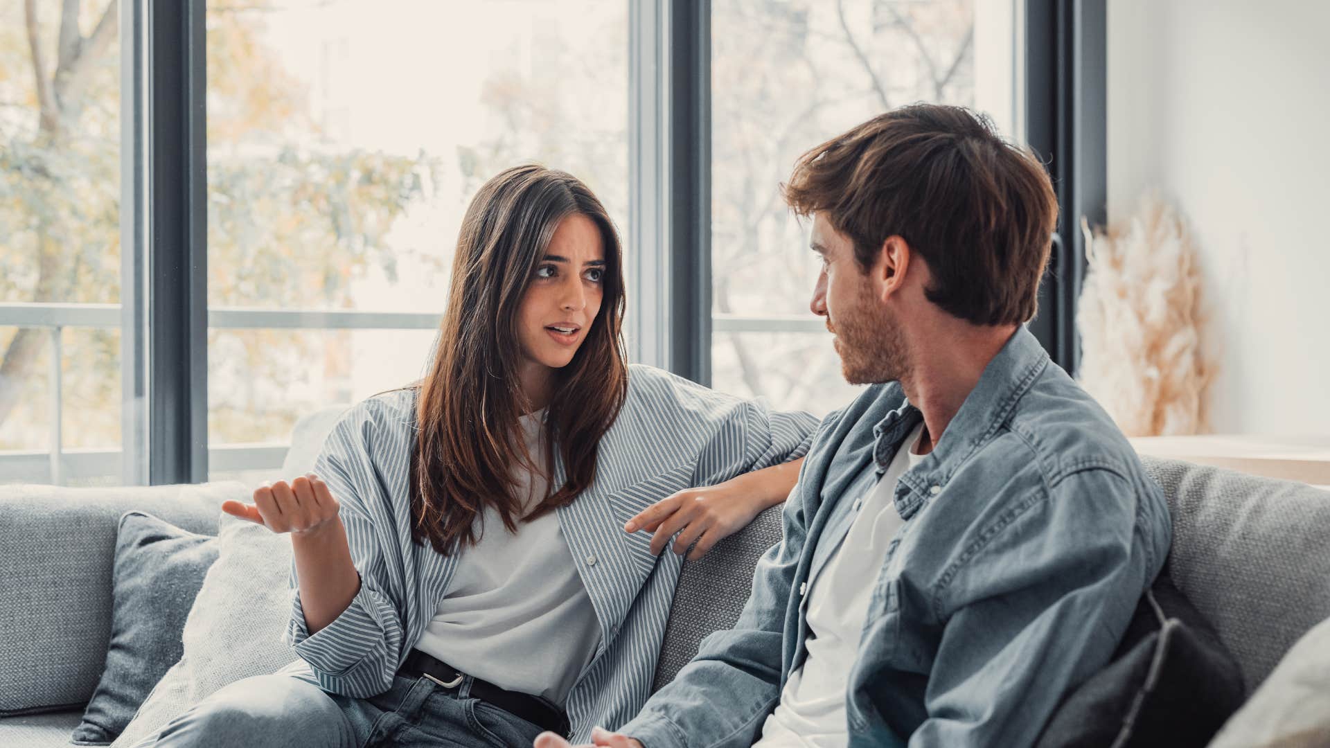 man showing woman he's not going anywhere as he listens to her