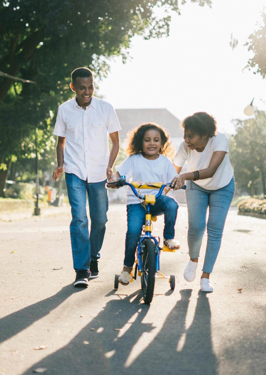 little girl riding a bike with her parents baltimore standing up violence good news world