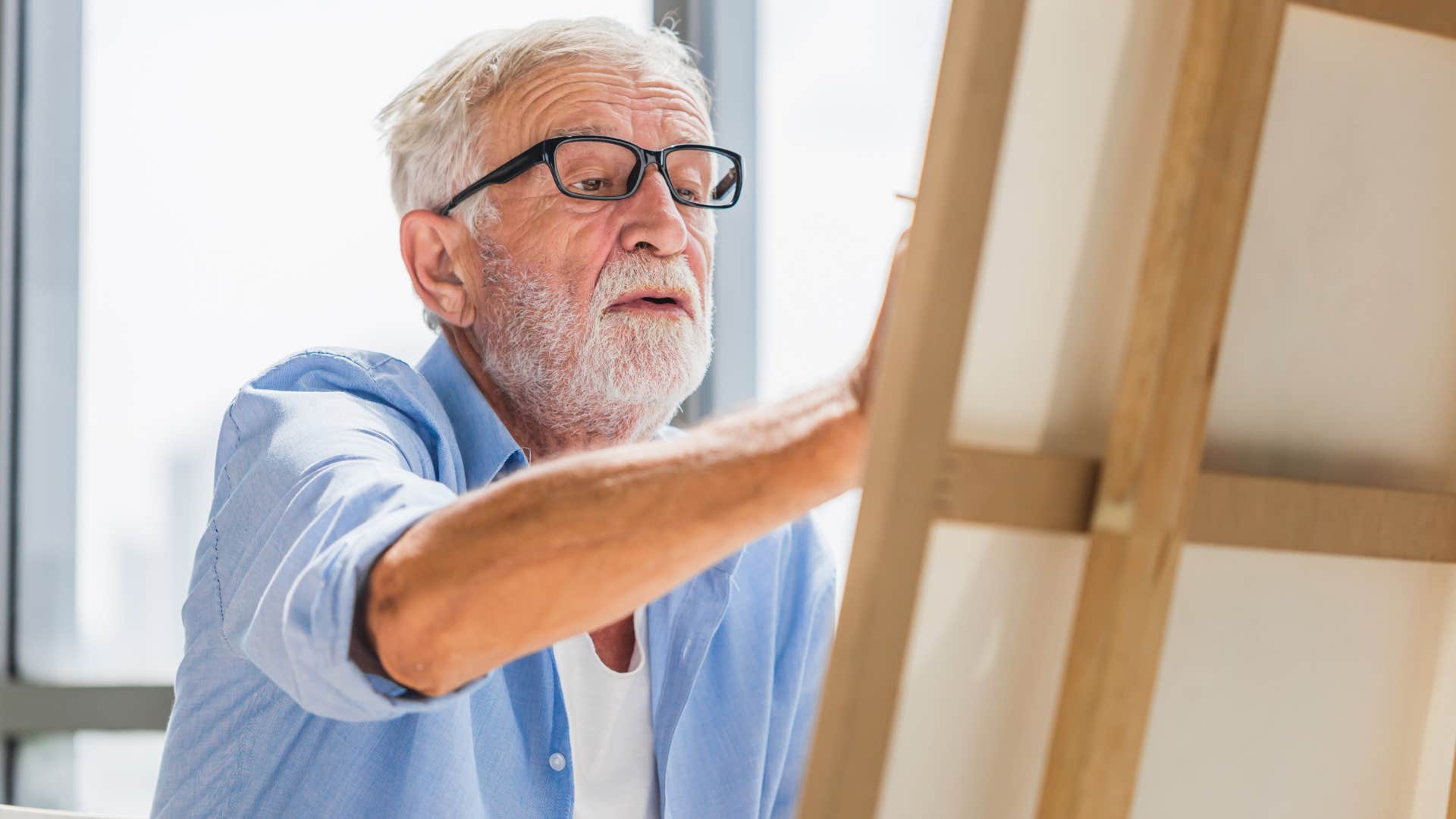 incredibly creative man painting on canvas