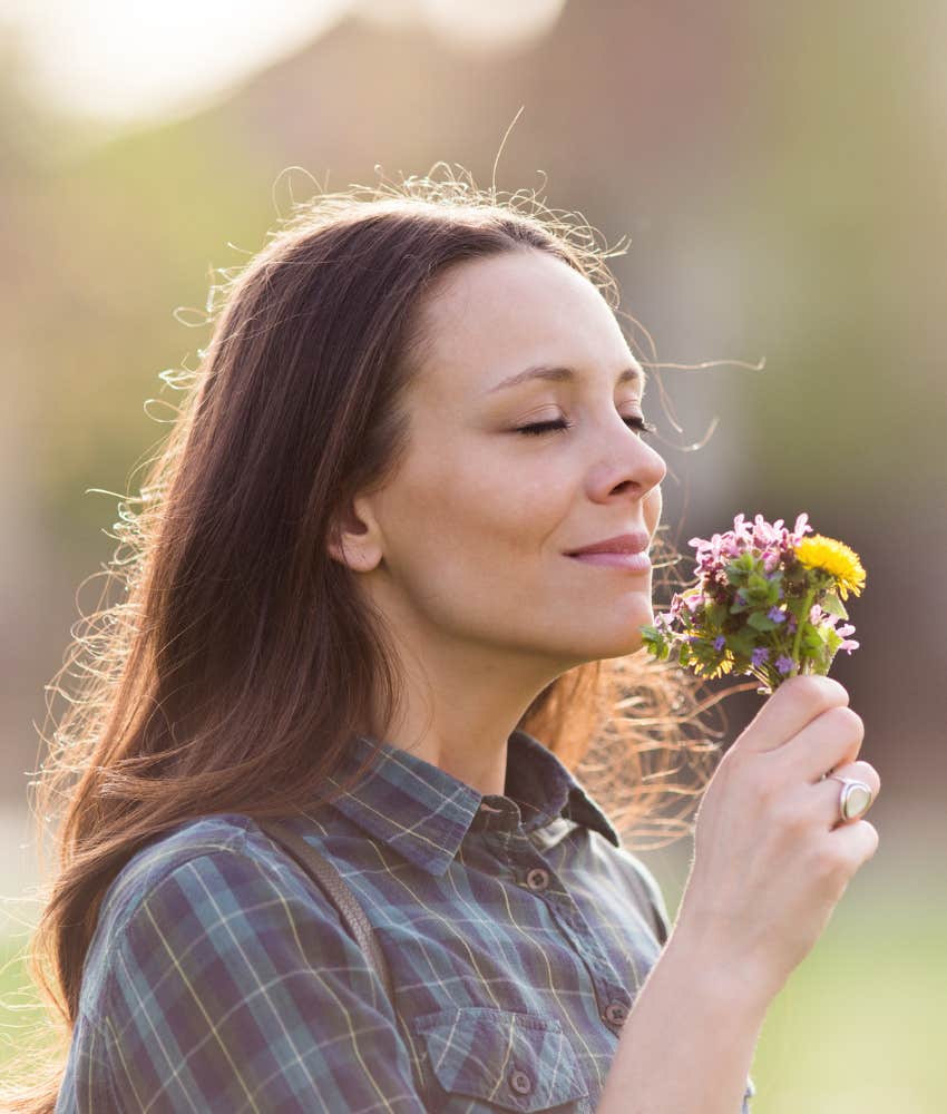 Joyful person smells flowers showing rule to make most of life