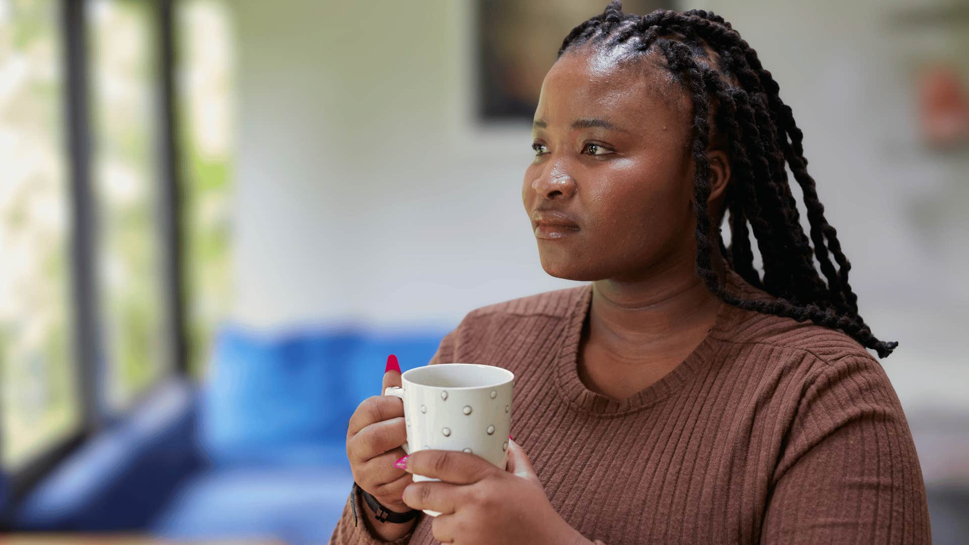 serious woman holding mug fearing the unknown