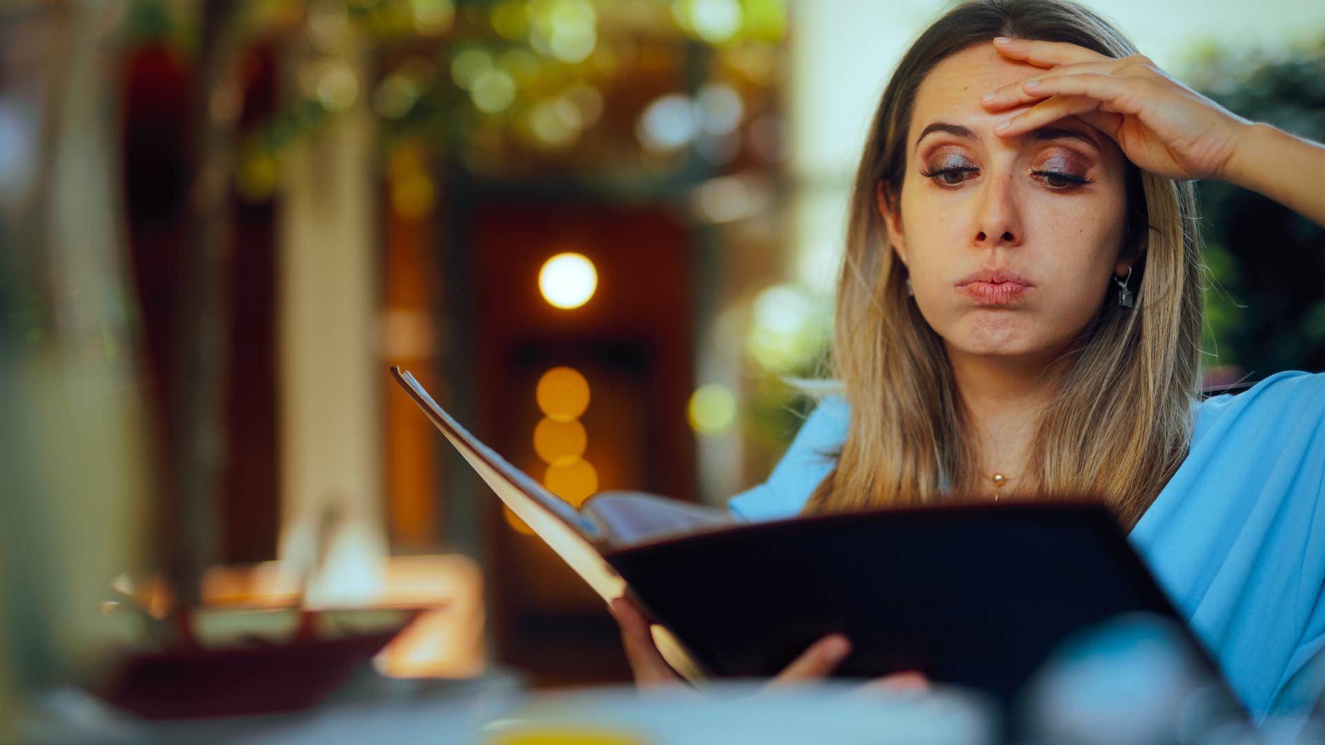 woman in blue looking stressed as she never comments on how expensive everything is