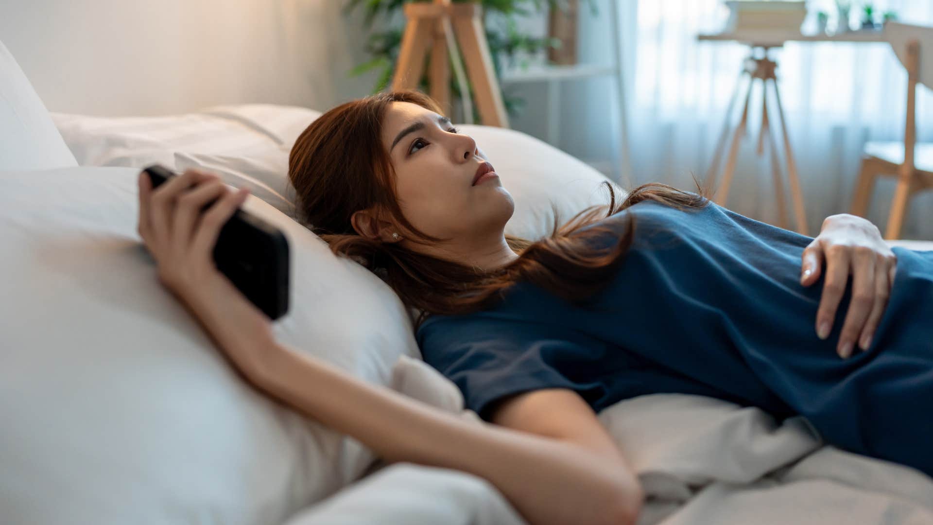 woman laying in bed downplaying her own needs