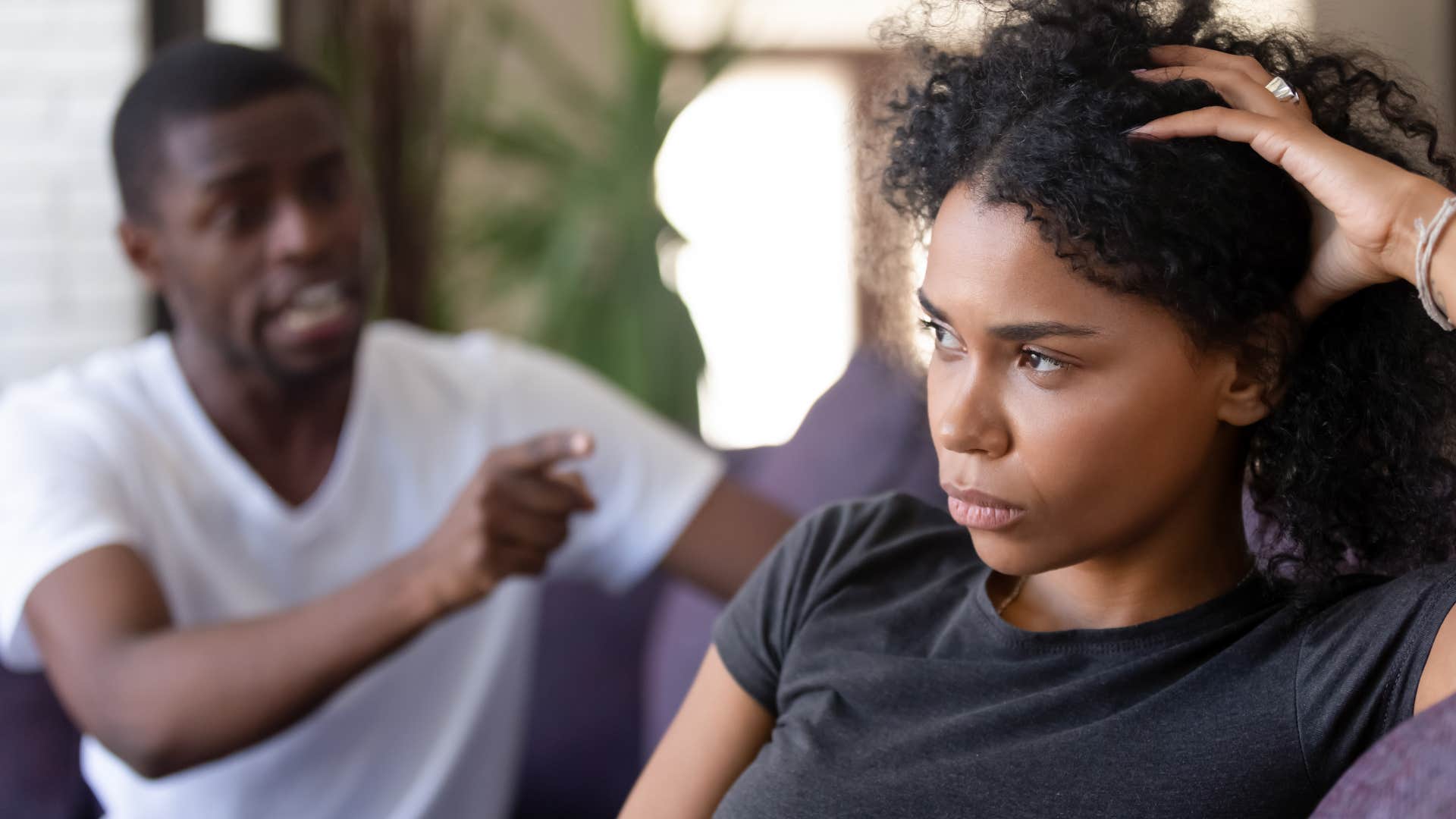 man being demanding of woman pointing at her angrily