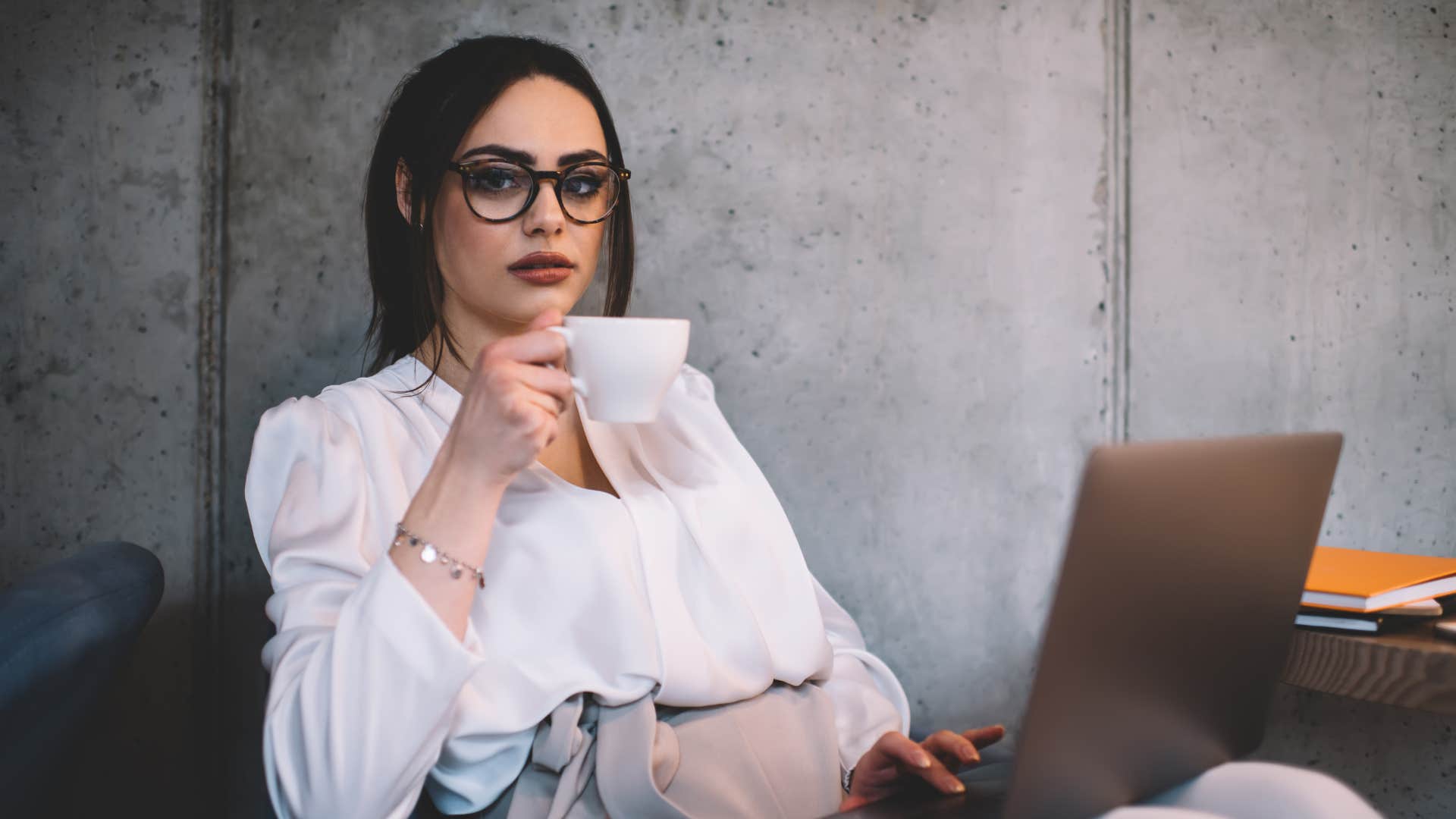 woman feeling relieved at work drinking coffee