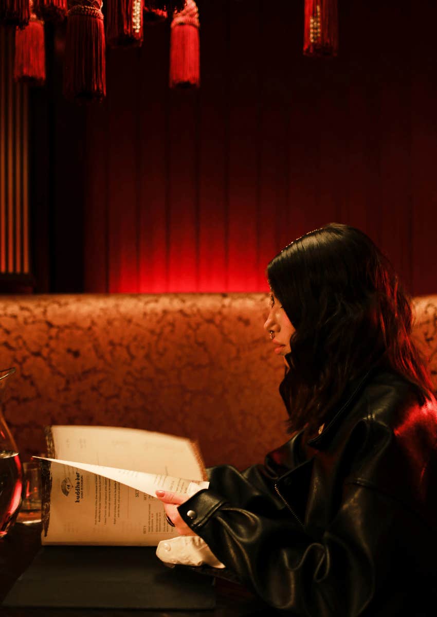 woman looking at food menu in a restaurant alone