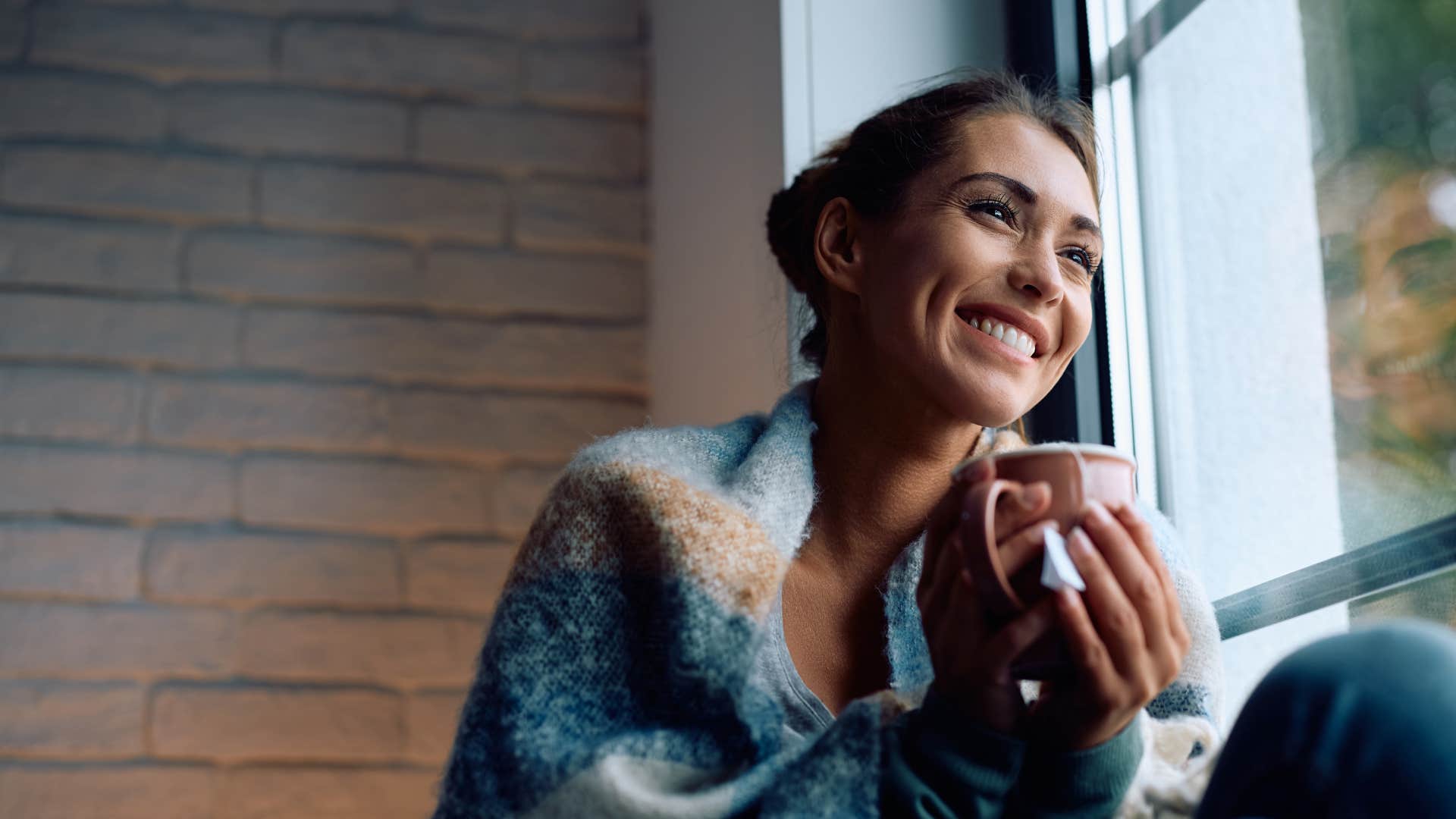 smiling woman in cardigan drinking tea 
